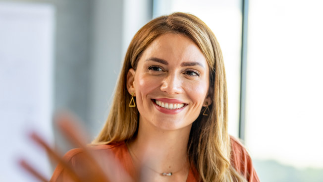 A woman smiles while leading a meeting